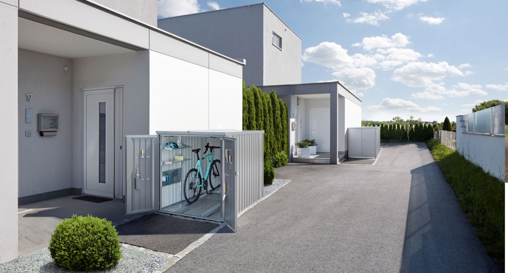 Hellgraue Biohort MiniGarage: Fahrradgarage aus Metall in einem Neubaugebiet bei Nürnberg.