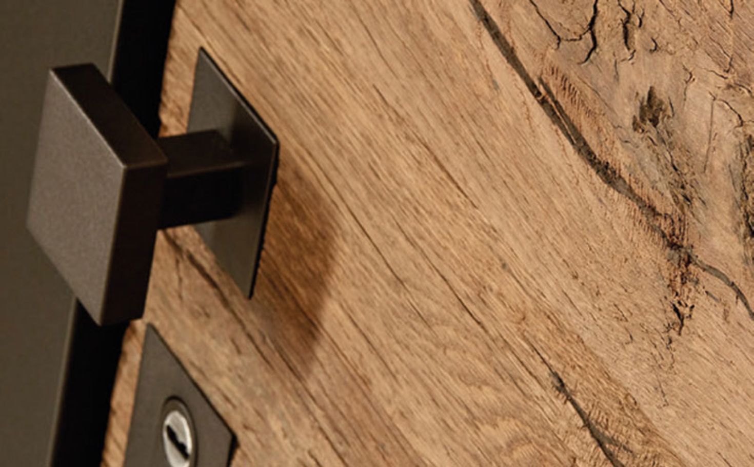 Detail einer Holzhaustür von Kutz mit schwarzem Türgriff auf hochwertiger natürlicher Holzoberfläche.